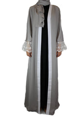 woman wearing an abaya in silver embellished with lace sleeves and a matching hijab