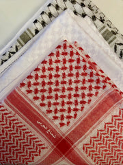 red, black, and white shemagh stacked on top of each other in a bundle