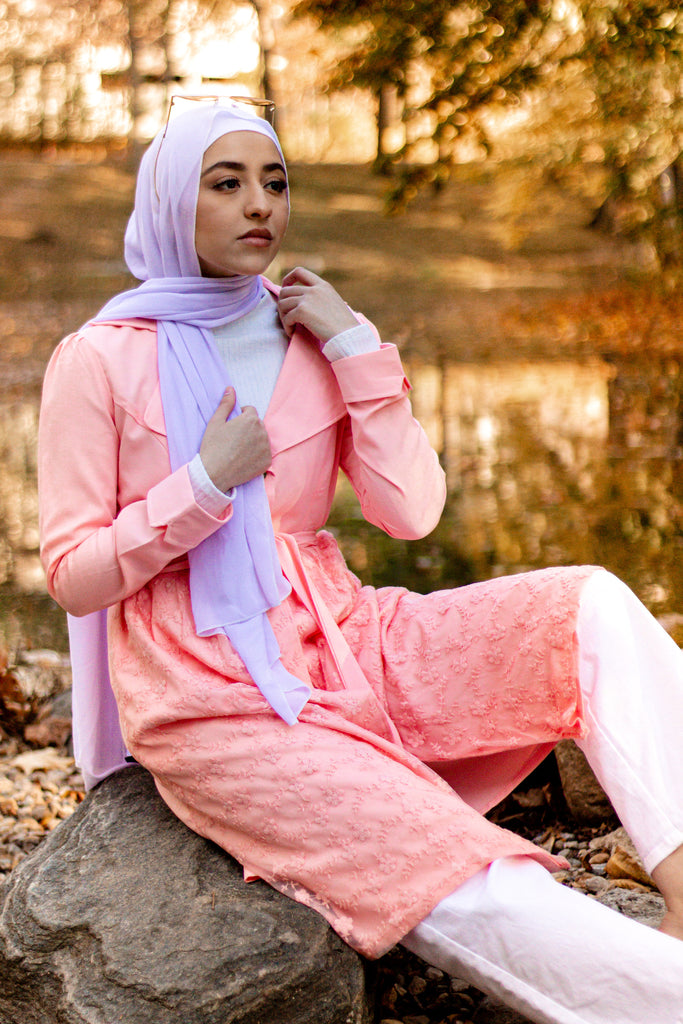 hijabi woman wearing a white chiffon hijab surrounded by a fall theme and wearing a lace jacket