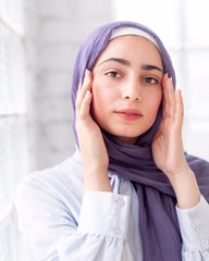 muslim woman wearing a purple modal hijab and white long sleeved top