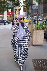 black muslim woman wearing a light purple lilac periwinkle lavender modal hijab with a checkered long sleeve black and white maxi dress