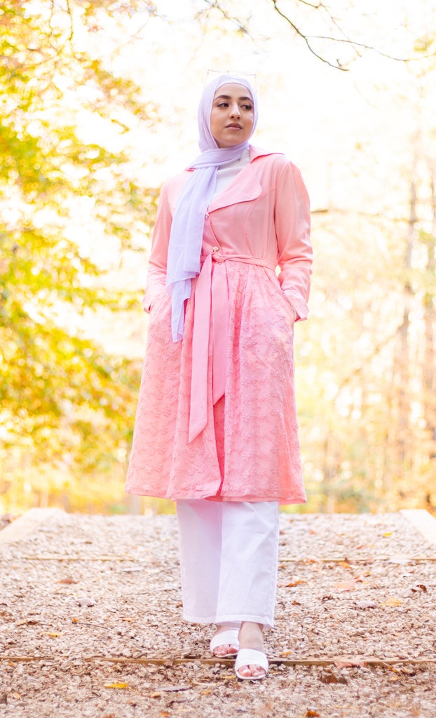 hijabi woman wearing a white chiffon hijab surrounded by a fall theme and wearing a lace jacket
