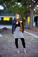 muslim woman wearing a mocha brown modal lace hijab modal hijab with lace on the ends and a leather bomber jacket and pencil checkered skirt