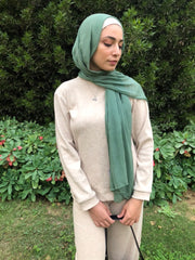 muslim woman wearing a light green seafoam modal hijab with a beige loungewear set