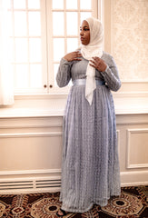 black muslim woman wearing a powder blue lace maxi dress with long sleeves and a satin belt