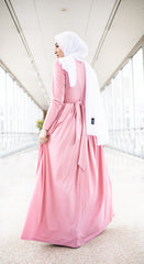 muslim woman wearing a criss cross pink long sleeve elegant maxi dress with a white chiffon hijab