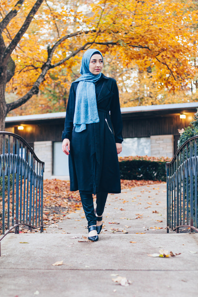 muslim woman wearing a black sleeveless cascade jacket with zipper pockets and a blue shimmer jersey hijab