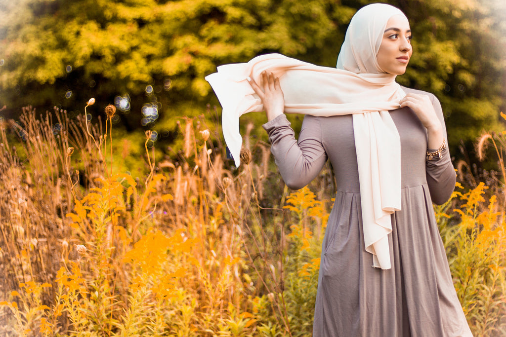 muslim hijabi woman wearing creme chiffon hijab and and long sleeve midi swing baby doll dress in taupe