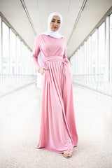 muslim woman wearing a criss cross pink long sleeve elegant maxi dress with a white chiffon hijab