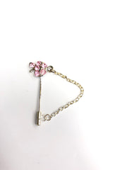 silver clasp pin with light pink apple jewel and a chain