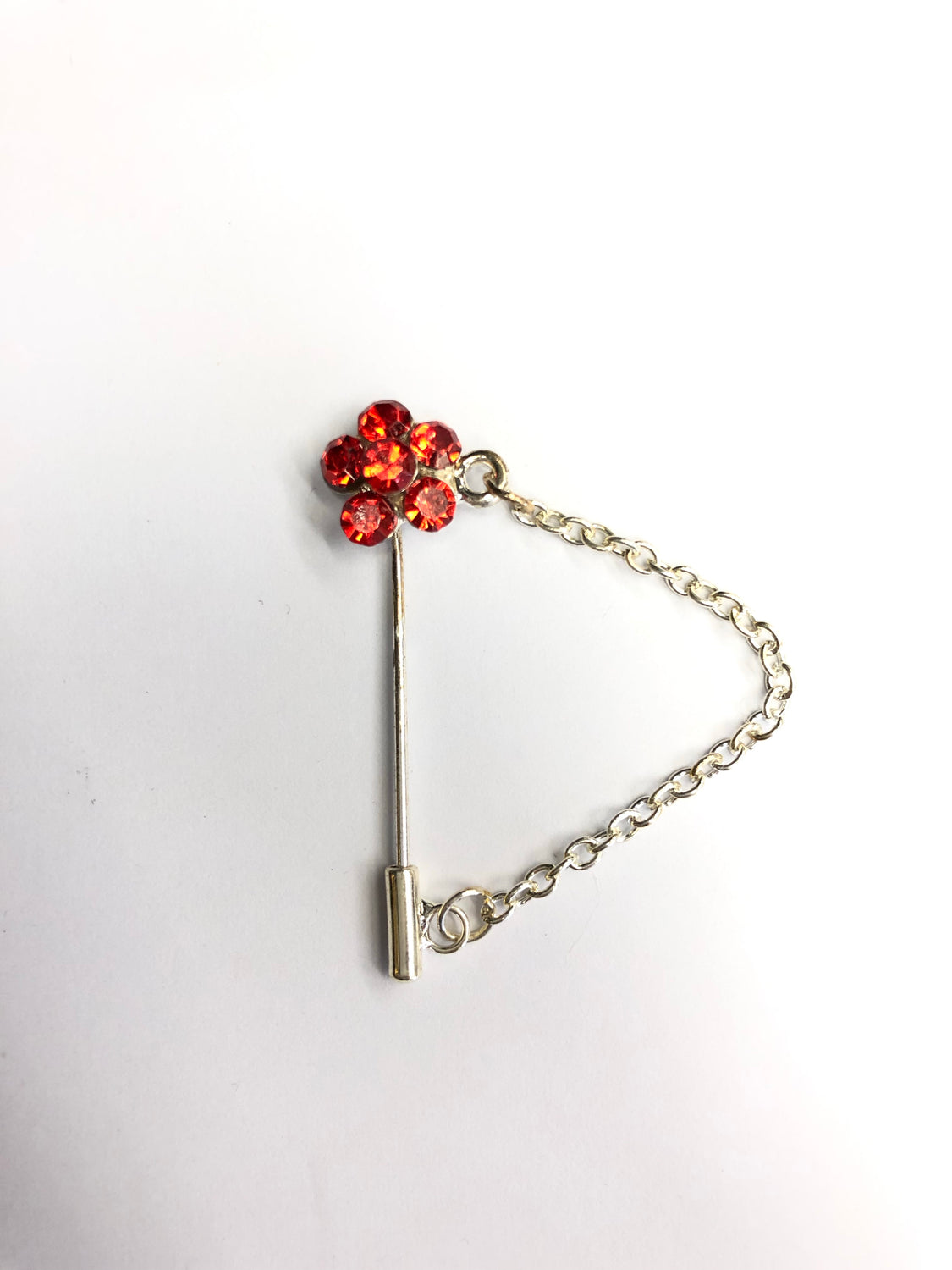 silver clasp pin with red floral jewel and a chain