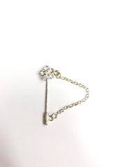 silver clasp pin with silver floral jewel and a chain