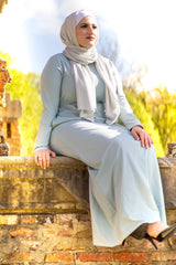 muslim woman in a sparkly silver jersey hijab and a light blue long sleeved maxi dress