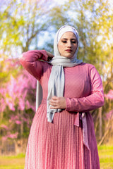 muslim woman wearing silver shimmer jersey hijab and a pink long sleeve maxi dress with polka dots and satin waist belt