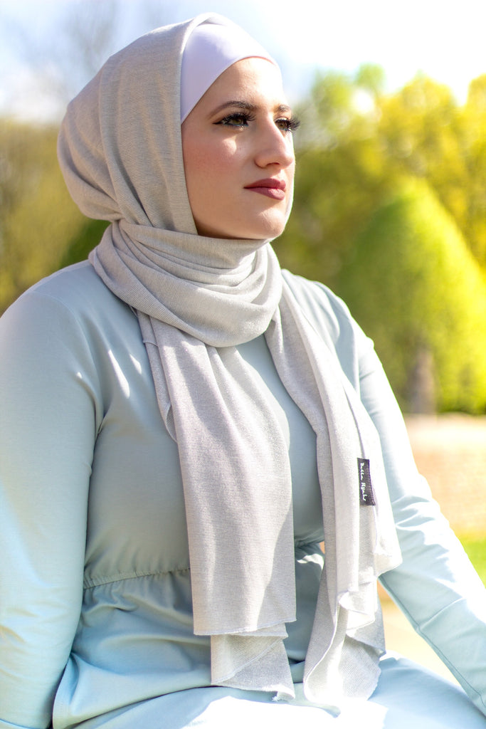 muslim woman in a sparkly silver jersey hijab and a light blue long sleeved maxi dress