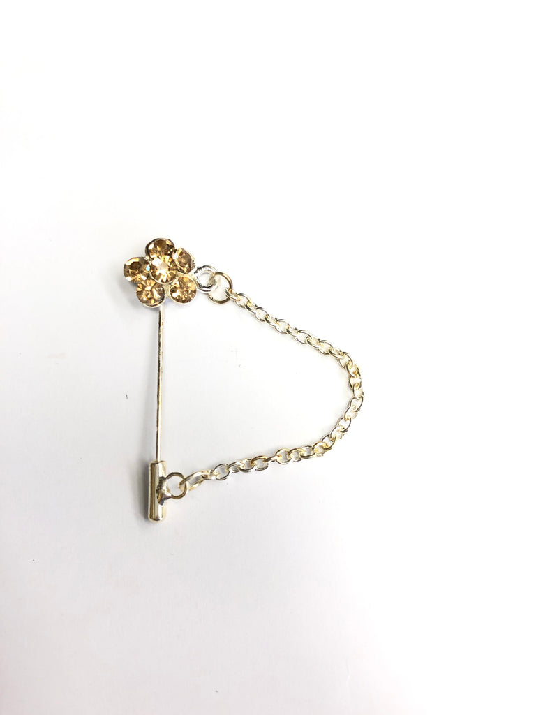silver clasp pin with gold floral jewel and a chain