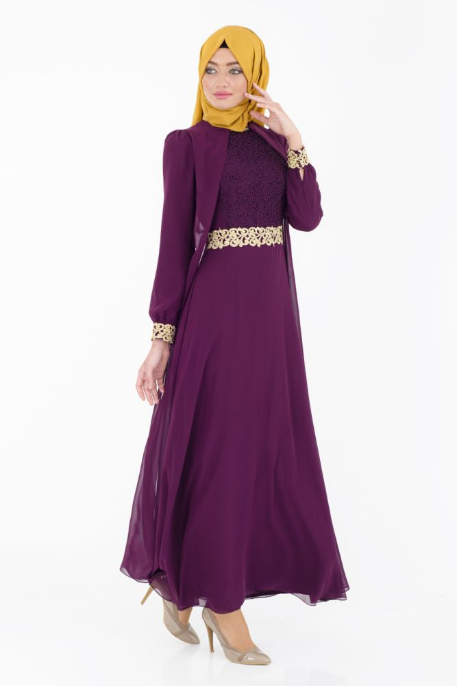 muslim woman wearing long sleeved maxi dress abaya with gold trimmed embroidery and a gold hijab
